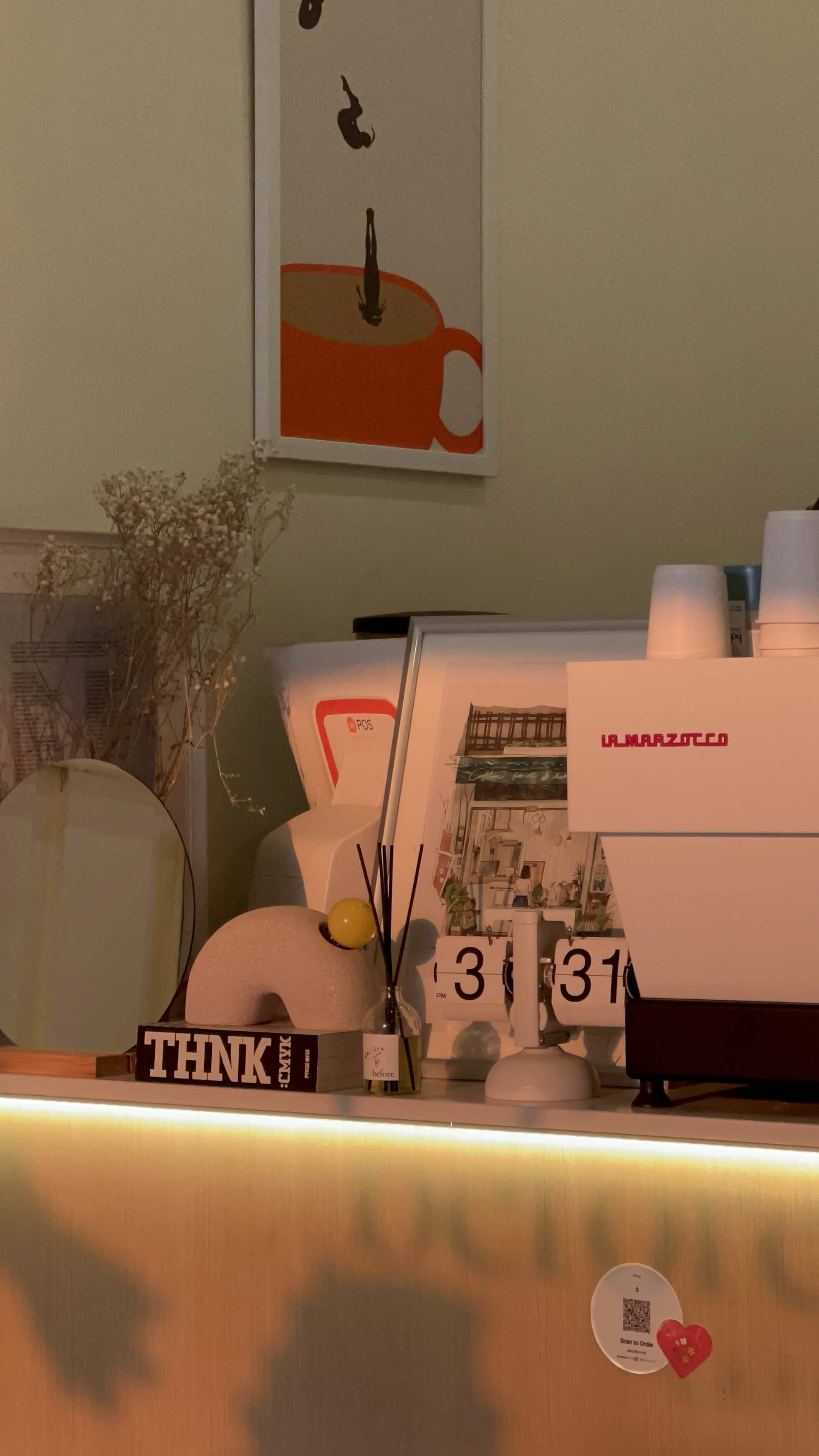 Counter with La Marzocco espresso machine and warm lighting
